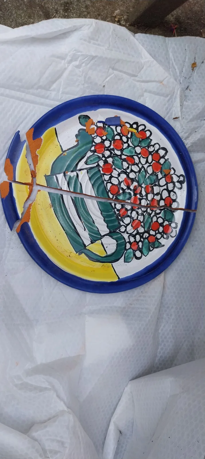 A yellow and blue decorated platter broken into pieces