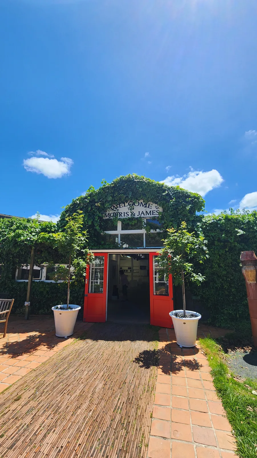The red doors and ivy-covered entrance with the Welcome to Morris & James sign