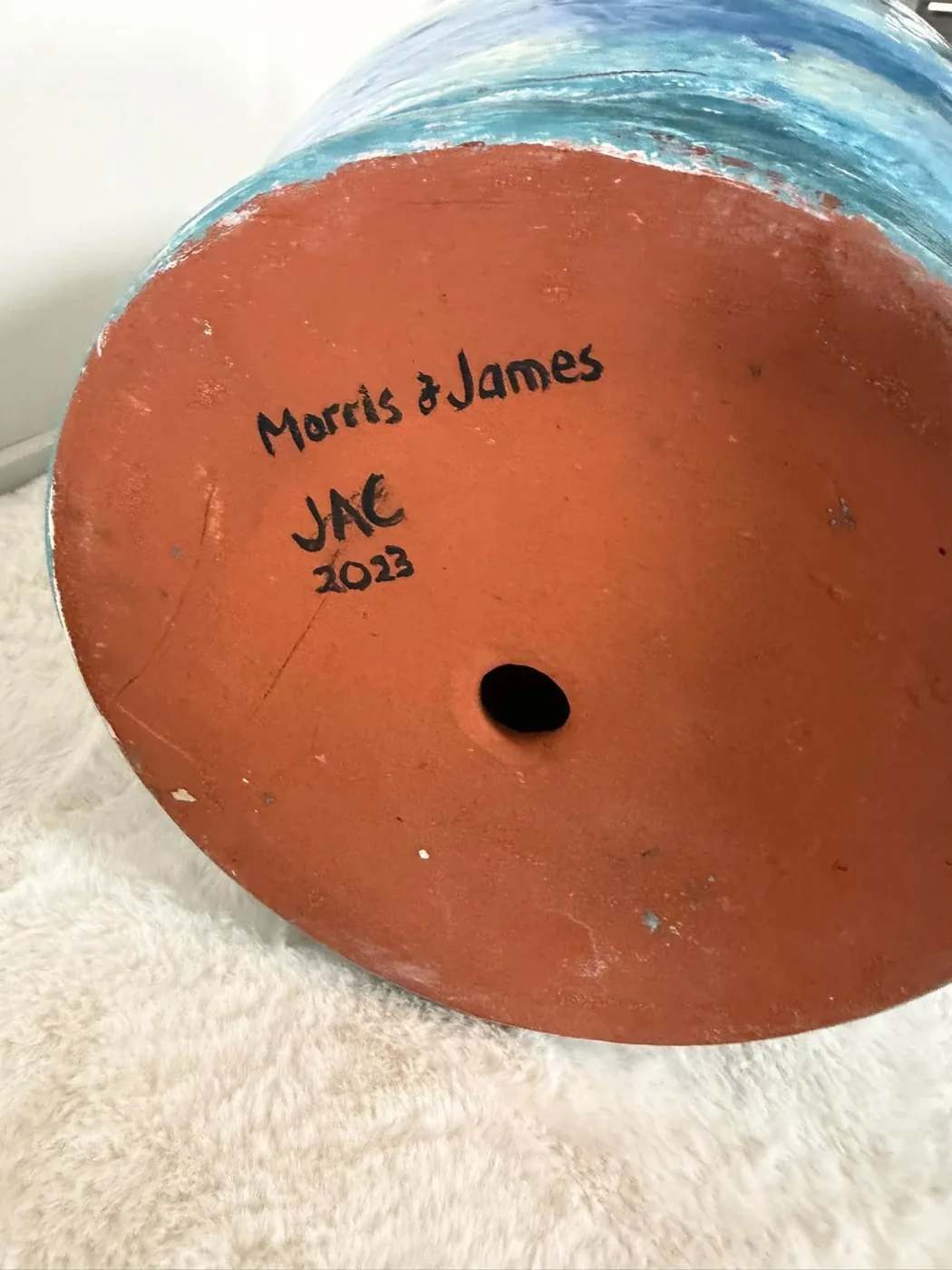 The terracotta underside of a hand-decorated Morris & James pot, signed Morris & James, JAC, 2023, by decorator Jac Connelly