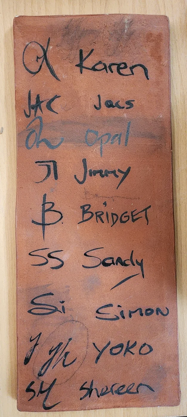 The glaze artists&rsquo; marks, recorded on a tile in the studio