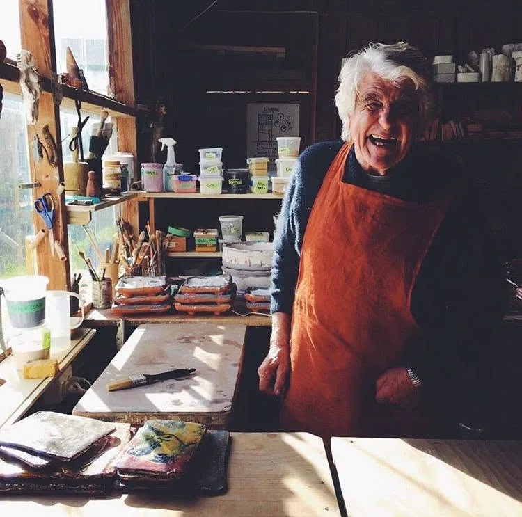 Anthony Morris laughing in his studio, wearing an orange apron