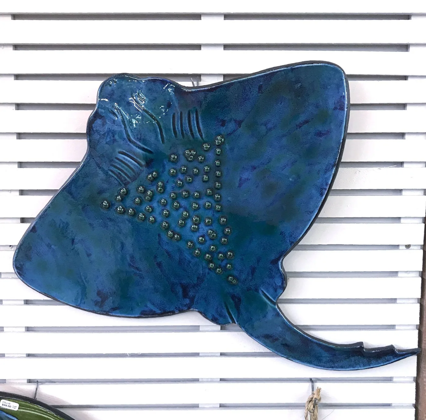 A blue-green stingray wall follie on white slats